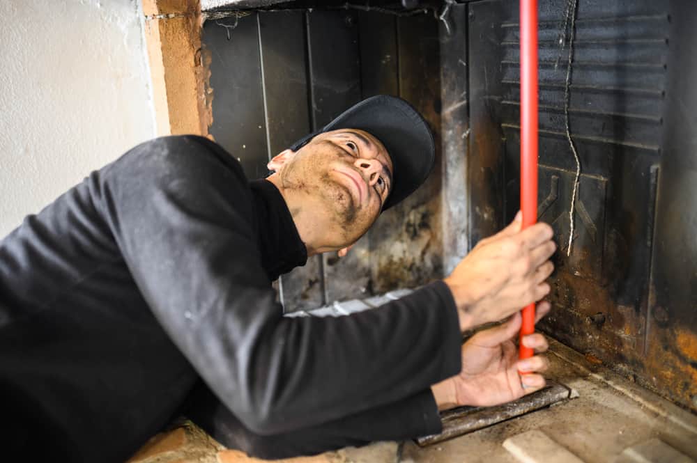 Young Chimney Sweep At Work Chimney Sweep Nassau County, NY
