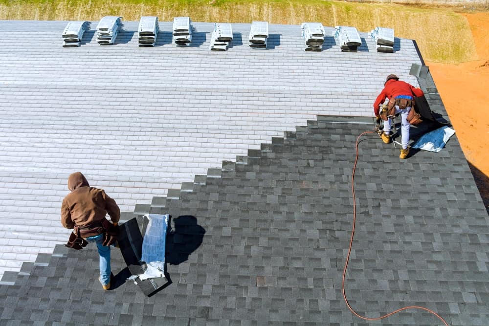 Aerial View In Worker Hands Installing Bitumen Roof Shingles Roofing Services Nassau County, NY